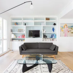 Vignette Une bibliothèque intégrée a été dessinée sur mesure. Le papier peint graphique, au fond des niches, donne de la profondeur.