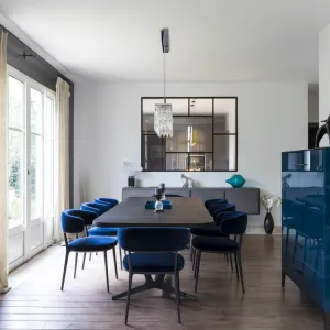 Vignette La salle à manger avec une grande table et chaises confortables au velours bleu